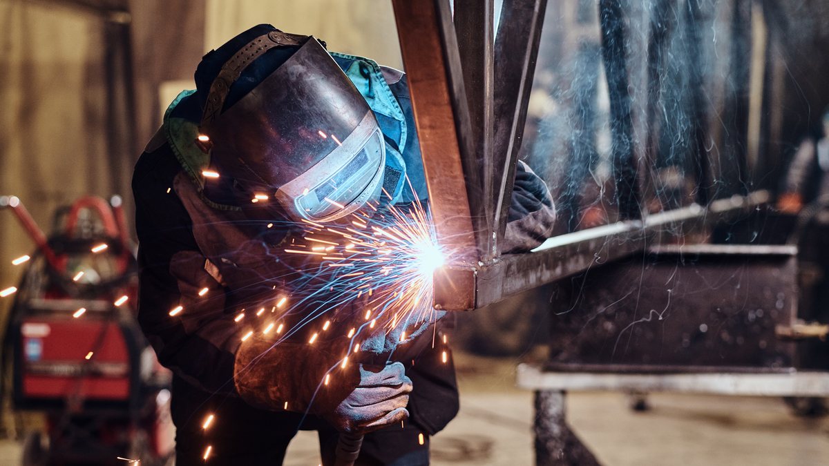 Welder fabricating structural steel framework
